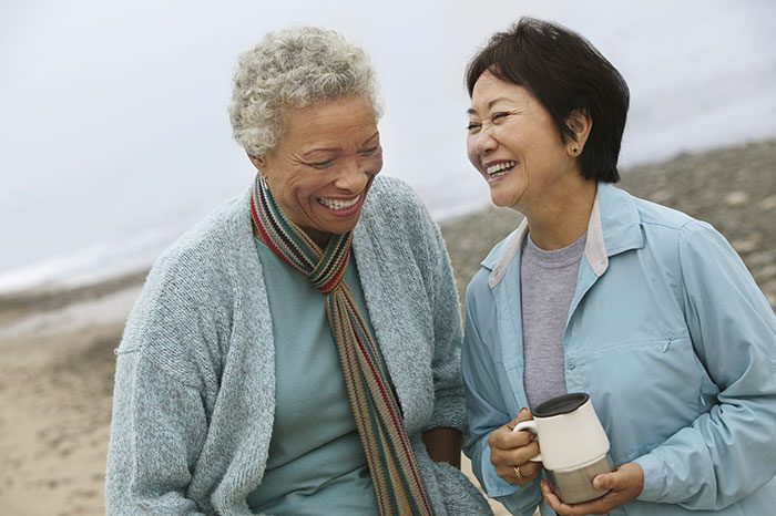 two smiling women together at the beach
